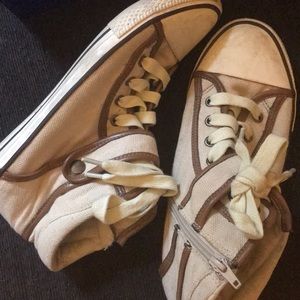 Off white ankle high, zipper closed canvas shoes.